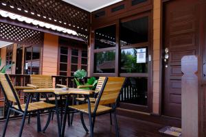 Une table et des chaises en bois sont disponibles sur la terrasse. dans l'établissement D'Razna Chalet Pantai Seberang Takir, à Kuala Terengganu