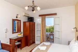 a bedroom with a bed and a desk and a mirror at Surfer Paradise in Naxos Chora
