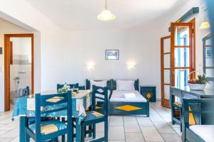 a room with a bed and a table and chairs at Surfer Paradise in Naxos Chora
