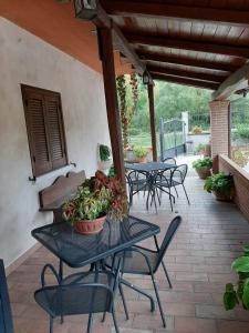 eine Terrasse mit Tischen und Stühlen mit Pflanzen in der Unterkunft Le Stanze di Bacco in Cagnano Amiterno
