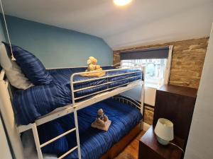 a bunk bed with two teddy bears sitting on top at Crosland Cottage in Holmfirth