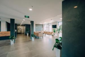 a lobby with couches and potted plants in a building at Hotel Doesi in Tbilisi City