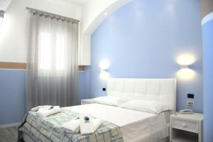 Un pat sau paturi într-o cameră la Hotel Città Bella