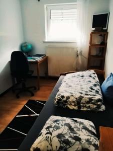Duas camas num quarto com uma secretária e um computador em 76 qm Whg im EG Haus-Wohlfühloase vor der Haustür em Gladenbach
