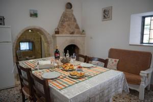 una mesa con comida y vino en la cocina en Trullo Monticello, en Martina Franca