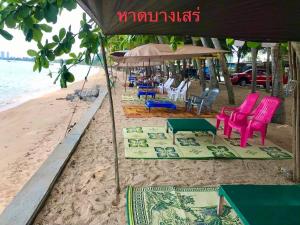 Baan Chang Residence في بانغ ساري: مجموعة من الكراسي والطاولات على الشاطئ