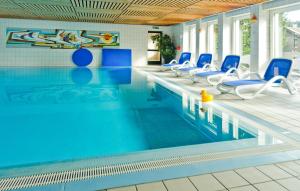 a large swimming pool with blue chairs and a swimming pool at Hotel Harz in Hahnenklee-Bockswiese
