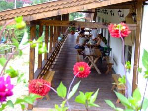 a wooden walkway to a restaurant with people sitting at tables at Pensiunea Cehov in Bran