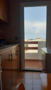 a kitchen with a sliding glass door to a balcony at Apparemment de luxury in Chozas