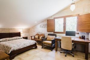Un dormitorio con una cama y un escritorio con una computadora. en Villa Casa de Campo Los Carballos, en Tomiño