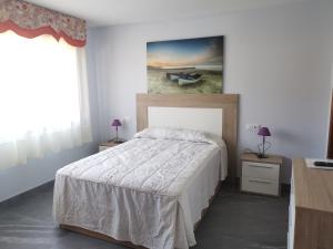 a bedroom with a bed and a painting on the wall at Casa Cadabón in Pontevedra