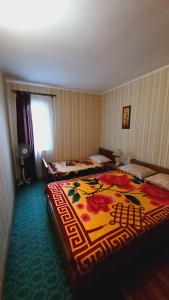 a bedroom with two beds with a colorful blanket at Otdykh u moria in Fontanka