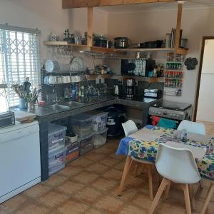 una cucina con un lavello e un tavolo con sedie di Neels Cottage a Clanwilliam