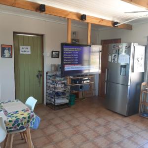 a living room with a television and a refrigerator at Neels Cottage in Clanwilliam