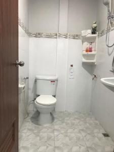 a white bathroom with a toilet and a sink at The Best House&Hostel in Ban Don Muang (1)