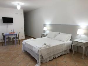 1 dormitorio con cama, mesa y TV en prima dell'opera, en Macerata