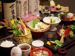 een tafel met kommen en borden met voedsel bij Kutsurogijyuku Shintaki in Aizuwakamatsu
