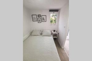 Un pequeño dormitorio blanco con una cama y una ventana. en Casita Dorotea, en Sabinosa