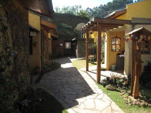 a stone walkway between two buildings in a yard at Hospedaria Vila Khepri in Gonçalves