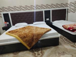 two beds in a bedroom with a blanket on them at Vidya Guest House in Katra