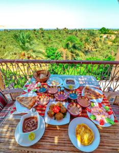 a table with plates of food on top of a table at Tache Boutique Hotel Fayoum in Fayoum