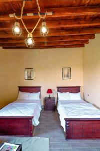 two beds in a room with wooden ceilings at Tache Boutique Hotel Fayoum in Fayoum Center