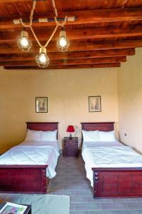 two beds in a room with wooden ceilings at Tache Boutique Hotel Fayoum in Fayoum