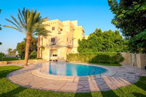 a house with a swimming pool in the yard at Tache Boutique Hotel Fayoum in Fayoum