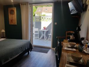 a bedroom with a bed and a door leading to a patio at LES LUPINS in Étretat