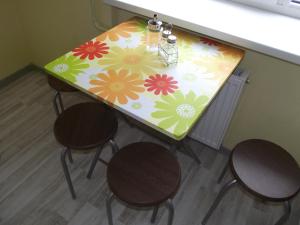 a table with a flower pattern on it with three chairs at Brīvības 21 Apartament in Ventspils
