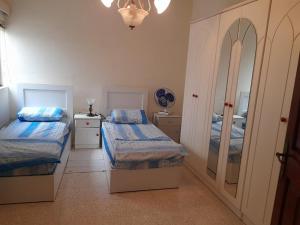a bedroom with two twin beds and a mirror at Dynesty B&B in Birżebbuġa