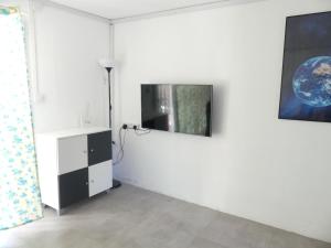 a living room with a tv on a white wall at Aquamarine - Grand Baie - 4 chambres - Piscine in Grand-Baie