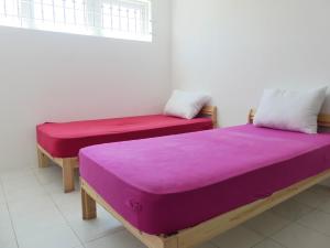 two beds sitting in a room with purple sheets at Aquamarine - Grand Baie - 4 chambres - Piscine in Grand-Baie