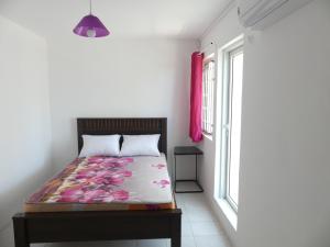 una camera da letto con un letto e una finestra di Aquamarine - Grand Baie - 3 chambres - Piscine a Grand Baie