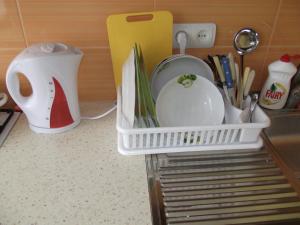 a white dish rack with dishes and utensils in a kitchen at Brīvības 21 Apartament in Ventspils