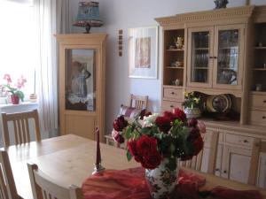 a dining room table with a vase of flowers on it at Pension Phönix in Sighişoara