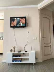 a flat screen tv hanging on a wall in a living room at Уютная квартира-студия в самом центре Пятигорска in Pyatigorsk