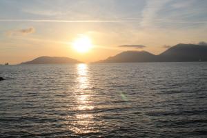 Una puesta de sol sobre el agua con montañas al fondo en House of Vera, en La Spezia 3 fotos más