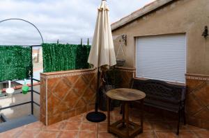 patio con mesa y sombrilla en el balcón en Casa Rural Cervarte, en Argamasilla de Alba