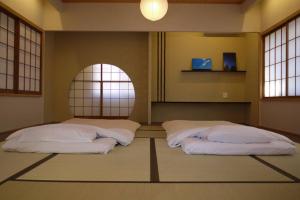 two beds in a room with a circular window at CHAKRA in Furukawachō