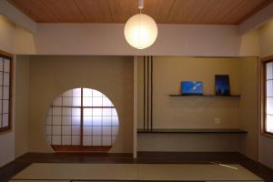 une chambre dotée d'une fenêtre circulaire et d'un éclairage dans l'établissement CHAKRA, à Furukawachō