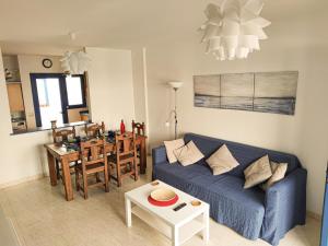 a living room with a blue couch and a table at VolKKanrentals Casa Machín in Famara