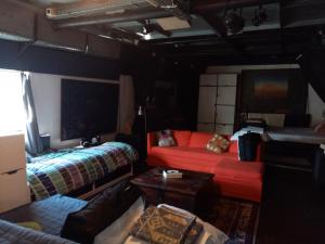 ein Wohnzimmer mit einem roten Sofa und einem Bett in der Unterkunft Edouard Boat in Brüssel