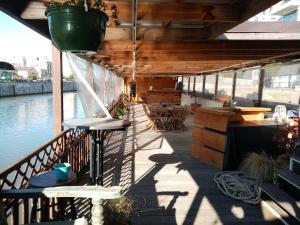 a deck with a table and chairs and water at Edouard Boat in Brussels