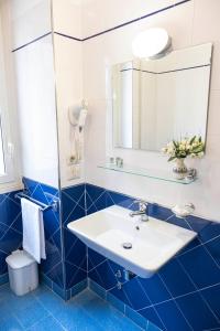a bathroom with a white sink and blue tiles at Villa Fatima, Casa per Ferie in Rome