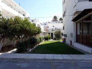 un cortile di un edificio con un cortile di erba di Andavis Hotel a Kardámaina