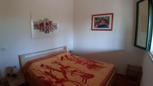 レウカにあるLa Casetta di Francescaのベッドルーム1室(赤い毛布付きのベッド1台付)