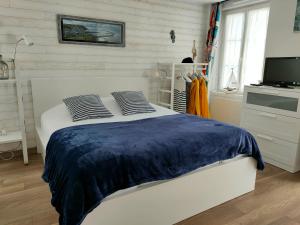 a bedroom with a bed with a blue blanket at Fishermen's Friend in Port-en-Bessin-Huppain