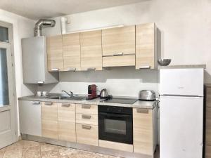 cocina con armarios de madera y nevera blanca en Bergamondo, en Bérgamo