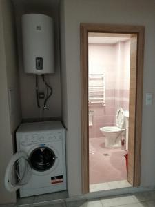 a bathroom with a washing machine and a toilet at Двустаен апартамент в Смирненски. До селената in Plovdiv